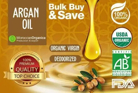 Pure cosmetic argan oil in a glass bottle with argan kernels on a neutral background